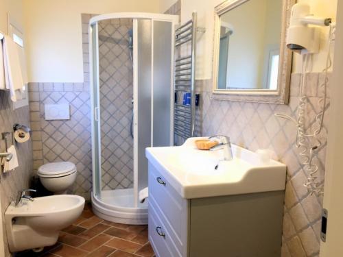 uma casa de banho com um lavatório, um chuveiro e um WC. em Affittacamere Anselmi Sauro em Portoferraio