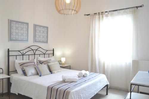 ナクソス・コラにあるAriadne & Theseus Apartmentsの白いベッドルーム(タオル付きのベッド付)