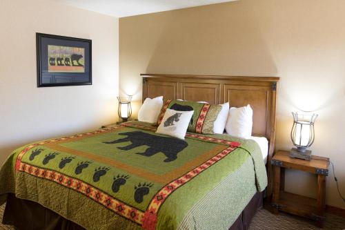 una camera da letto con un letto con un piumone verde di Crosswinds Inn a West Yellowstone