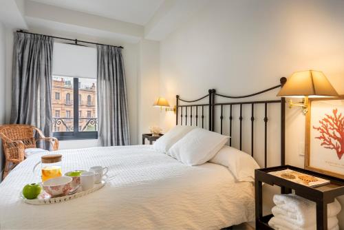 Un dormitorio con una cama con una bandeja de comida. en Apartamento La Catedral, en Sevilla