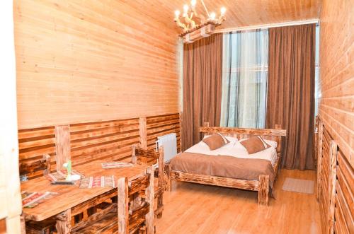 a bedroom with a bed and a table and a window at Zangezur Hotel in Goris