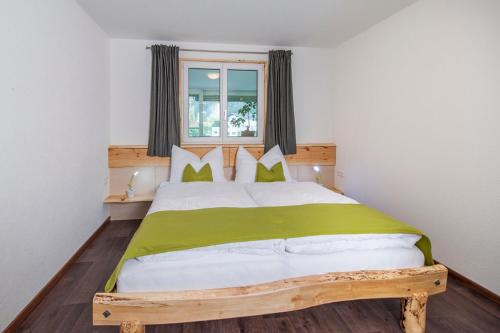 プルツにあるHaus Heissのベッドルーム(緑のシーツを使用した大きな白いベッド付)