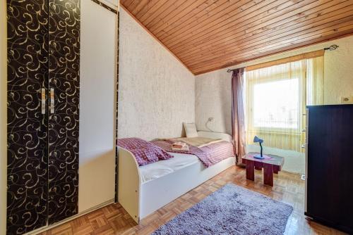 a small bedroom with a bed and a window at D&L Apartment in center in Pula