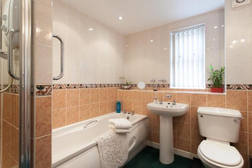 a bathroom with a toilet and a sink and a bath tub at Oil Mill Lane Holiday Cottage in Berwick-Upon-Tweed
