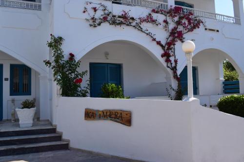a white building with a sign on a wall at Kalimera Studios and Apartments in Moraitika