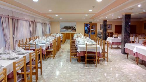 a dining room filled with tables and chairs at Hotel La Lanzada in A Lanzada
