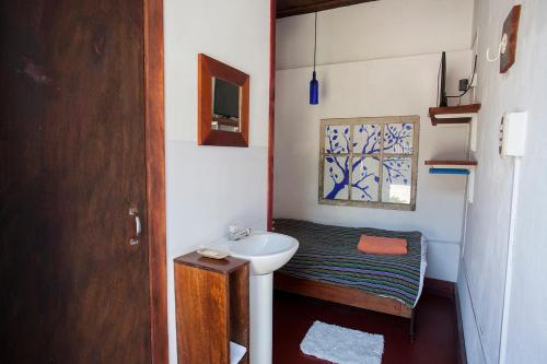 a small bathroom with a sink and a bed at Hotel Casa Chapultepec in Cobán