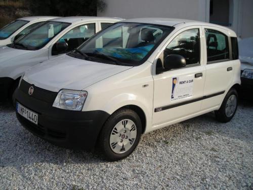a white car parked next to two other cars at Gryspo's Hotel in Aegiali