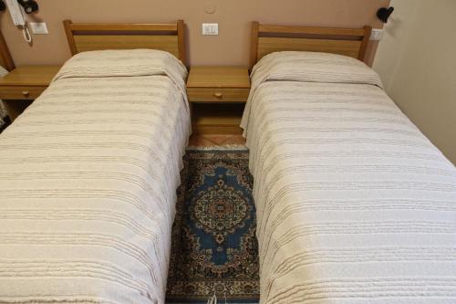 two beds sitting next to each other in a room at Albergo Gusmeroli in Tirano