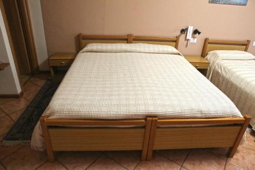 a bed in a room with two nightstands and sidx sidx sidx at Albergo Gusmeroli in Tirano