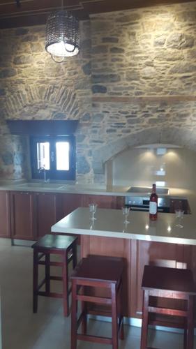 a kitchen with a counter with stools and a counter top at Villa Pavlos in Symi