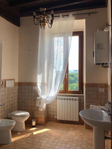 a bathroom with two sinks and a toilet and a window at Casa Vacanze La Torretta in Sutri
