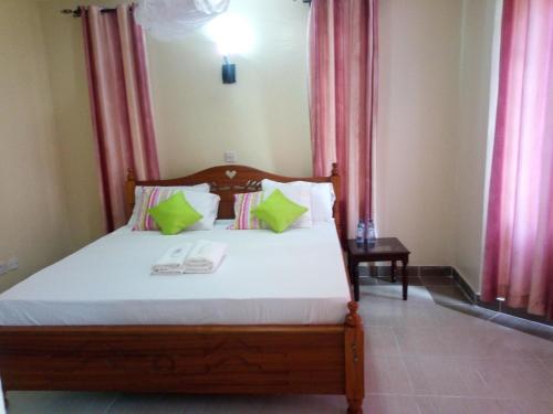 um quarto com uma cama com almofadas verdes em Savannah Luxury Apartment em Nairobi