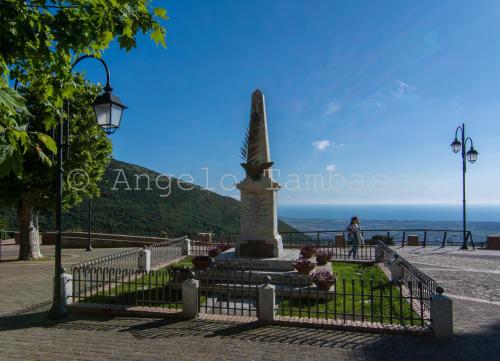 a statue sitting on a bench next to the ocean at Casa Delle Rose in Capaccio-Paestum