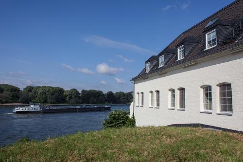 a boat traveling down a river next to a building at Schnellenburg in Düsseldorf