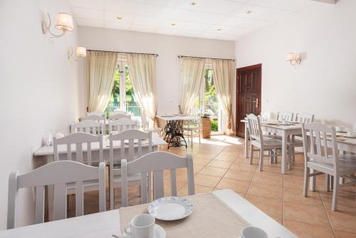une salle à manger avec des tables et des chaises blanches dans l'établissement Willa Kaszubska - Przepyszne Śniadanie w Cenie, à Jastrzębia Góra