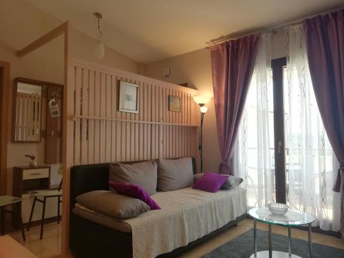 1 dormitorio con 1 cama con almohadas moradas en Idea Podstrana, en Podstrana