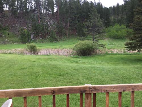 a view of a green field with a wooden fence at Black Elk Resort in Hill City