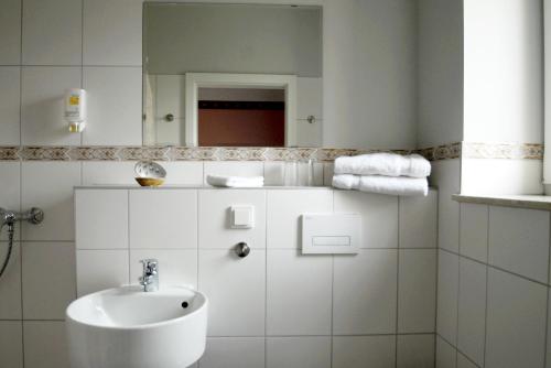 a white bathroom with a sink and a mirror at Cellino Hotel Prieros in Prieros