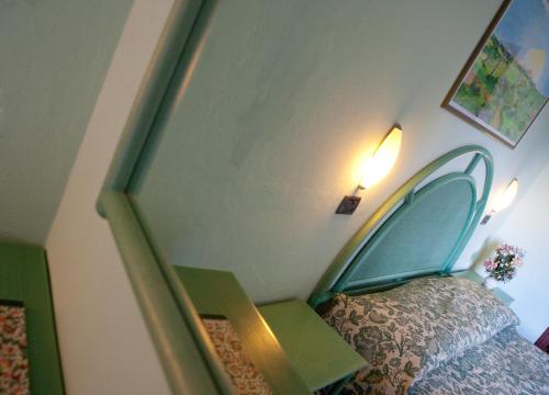 a bedroom with a bed with a green headboard at Hotel Danila in Portoferraio