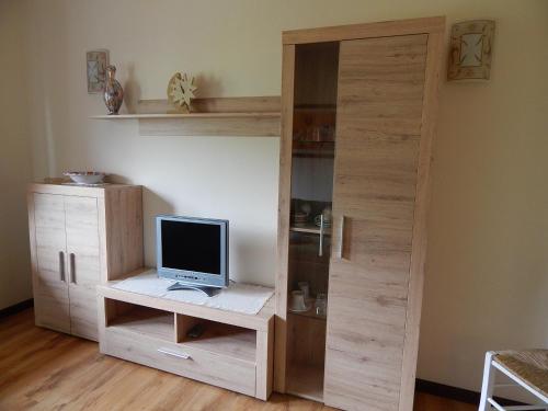 a wooden bookcase with a computer on a desk at Residence La Pineta in Padola