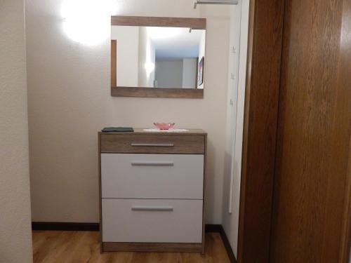 a bathroom with a dresser and a mirror at Residence La Pineta in Padola