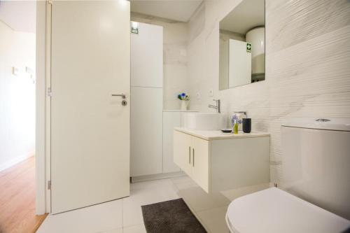 La salle de bains blanche est pourvue de toilettes et d'un lavabo. dans l'établissement Green Suite, à Porto