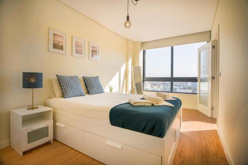 een slaapkamer met een bed en een groot raam bij Green Suite in Porto