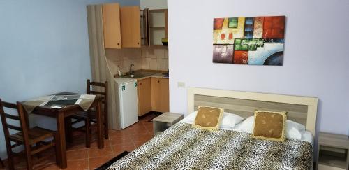 a room with a bed and a table and a kitchen at Berti Apartment in Vlorë