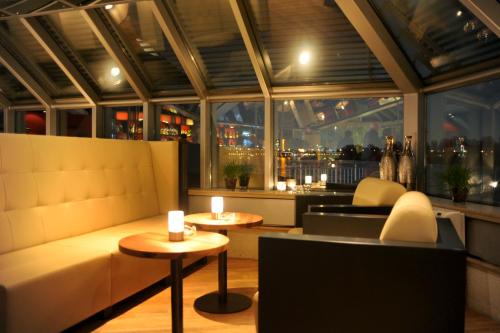 a restaurant with a couch and tables and a window at Schnellenburg in Düsseldorf