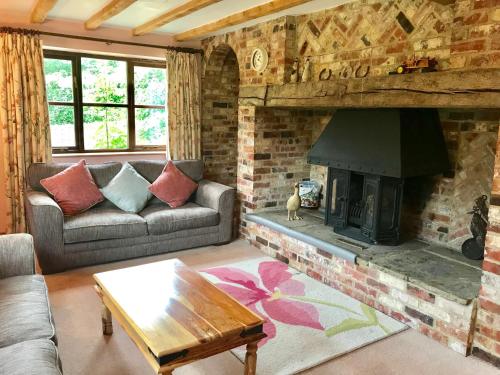 a living room with a couch and a fireplace at The Turkey House in Petersfield