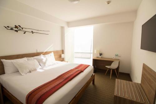 una camera d'albergo con letto e scrivania di Tierra Viva Miraflores Mendiburu a Lima