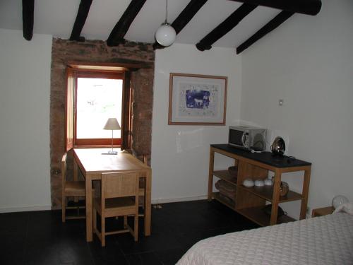 a bedroom with a bed and a desk and a window at Quinta da Alagoa in Santa Maria de Émeres