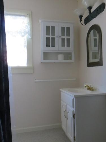 a white bathroom with a sink and a mirror at Cooperstown Bed and Breakfast in Cooperstown