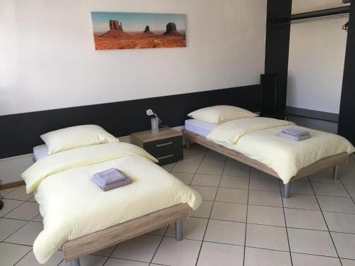 2 bedden in een kamer met witte lakens en kussens bij Studio Lora RM 1221 in Saint-Louis