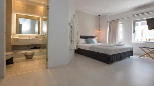 a bedroom with a large bed and a bathroom at Ermou Stylish Suites by GHH in Athens