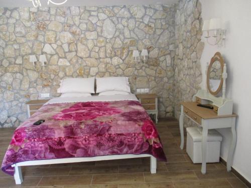 1 dormitorio con cama y pared de piedra en Korina Studios en Paleokastritsa