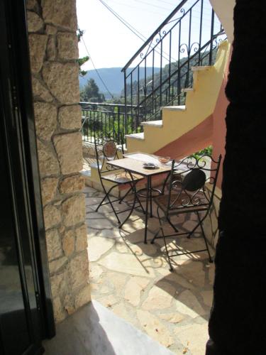 a patio with a table and chairs and stairs at Korina Studios in Paleokastritsa