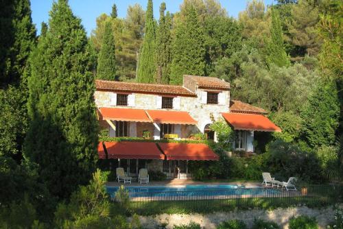 une maison avec une piscine dans une forêt dans l'établissement Chambres d'hôtes Il Monticello, à Grasse