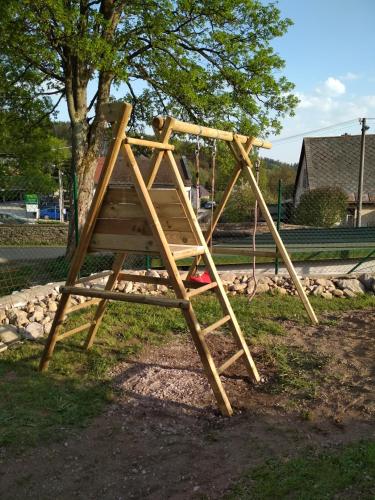 a wooden play structure with a swing at Chalupa Krkonoše in Cerny Dul