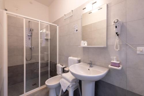 y baño blanco con lavabo y ducha. en Hotel Anny, en Lido di Jesolo