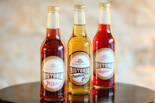 three bottles of beer sitting on a table at Hotel Historia Malomkert in Veszprém