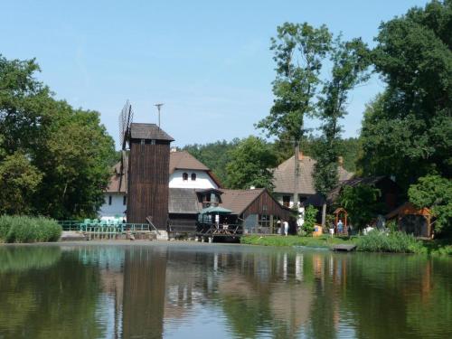 a building next to a body of water at Bučický mlýn in Rožďalovice