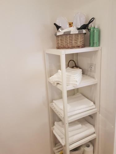 a white shelf with plates and a basket on it at Casa Tea in Bologna