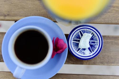 a cup of coffee and a red flower on a table at Kalamata Art Rooms in Kalamata