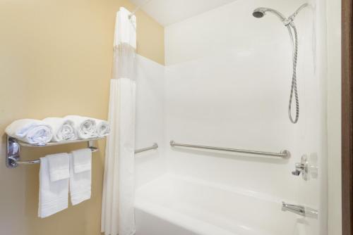 a bathroom with a shower and a toilet and towels at Days Inn by Wyndham Worland in Worland