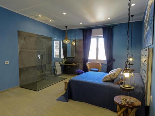 een slaapkamer met een bed en een glazen douche bij Catria in Favignana