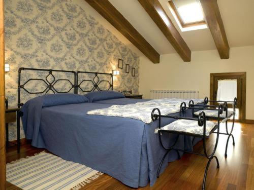 a bedroom with a bed with a blue comforter at El Lagar del Vero in Huerta de Vero