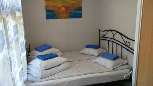 uma cama com almofadas azuis num quarto em Oakcorner Place Apartment em Haapsalu