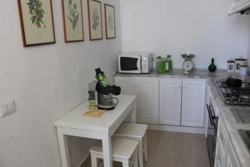 una cucina con un piccolo tavolo bianco e un forno a microonde di Casa Villa a Massa Lubrense